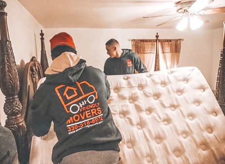 Two men moving a mattress in a room.