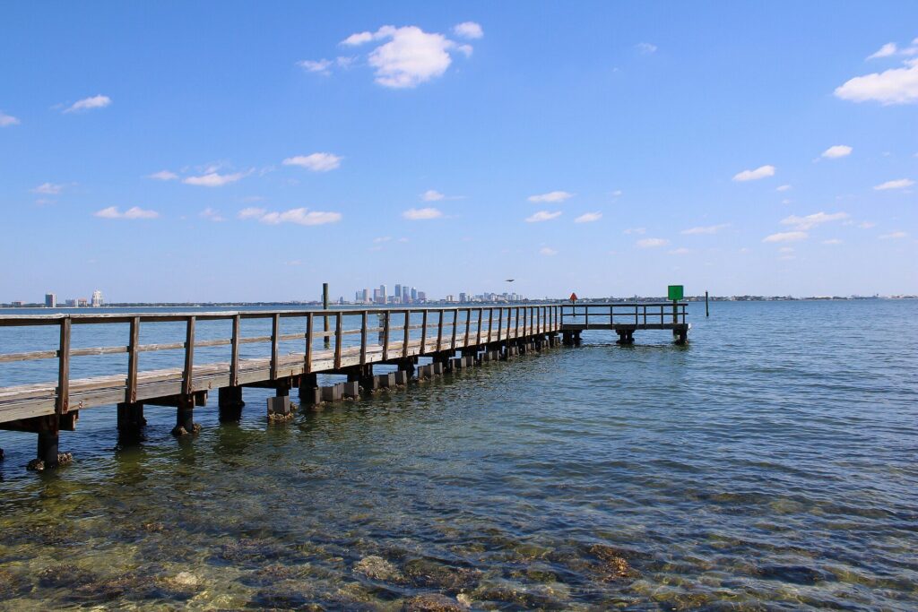 Wooden dock at Ballast Point Park on Hillsborough Bay with the downtown Tampa skyline in the distance
