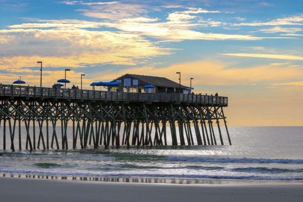 Sunset over Garden City Pier extending into the Atlantic Ocean in Garden City, South Carolina