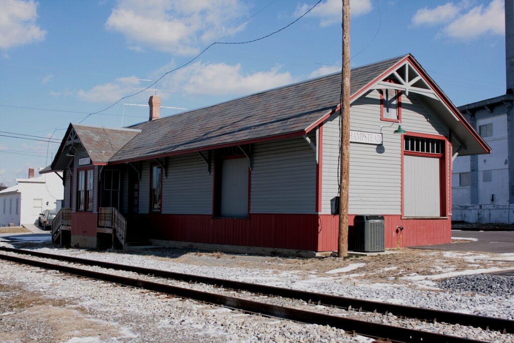 The restored Hampstead train station beside the railroad tracks in Hampstead, Maryland