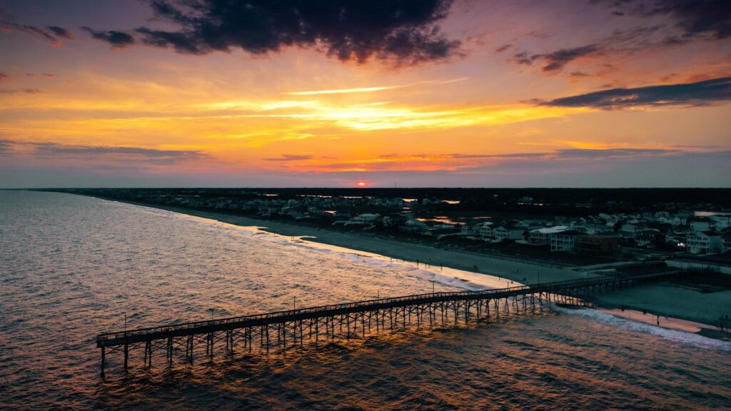Sunset over Holden Beach, NC, with a pier in the foreground