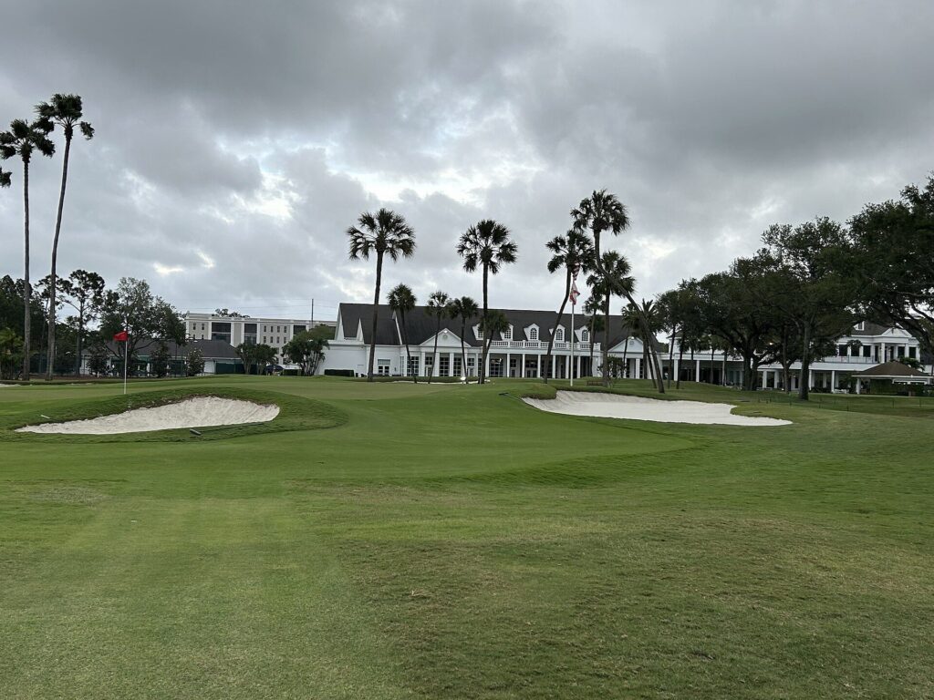 Palma Ceia Golf & Country Club clubhouse behind a green with palm trees in South Tampa
