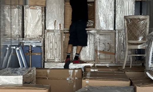 A & M Friendly Movers crew loading a truck with wrapped furniture and boxes