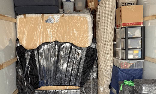 Furniture padded and shrink-wrapped inside an A & M Friendly Movers truck
